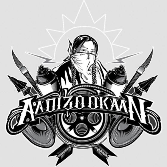 Graphic design of the word "AADIZOOKAAN" in embellished capital letters, surrounded by drawings of paintbrushes, spray paint cans, speakers, arrow heads and arrow feathers. Above the word is a drawing of a person with two braids wearing a kerchief tied over nose and mouth like a mask. Behind the person is an outline of the sun.